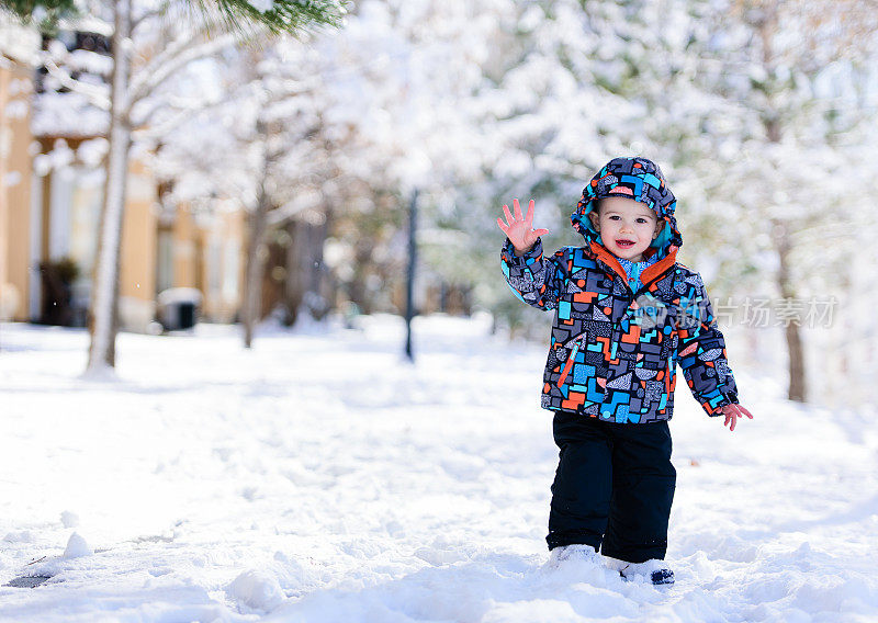 蹒跚学步的男孩在雪中飘扬