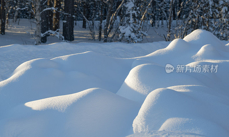 暴风雪过后，小雪堆在阳光下的小山