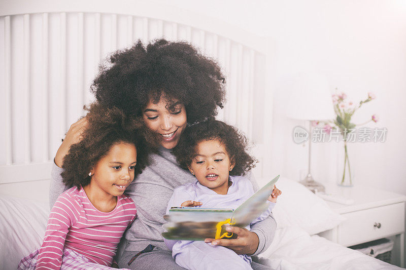 母亲和女儿们在床上看书