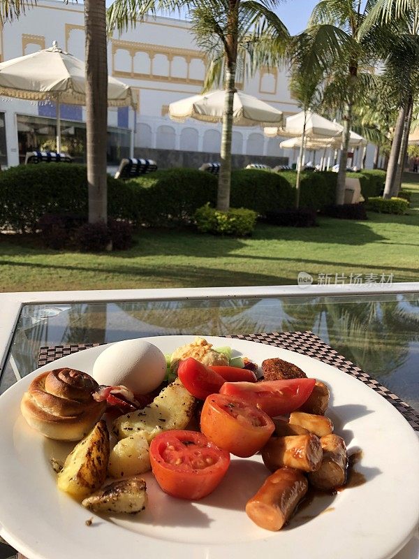 印度德里酒店自助早餐:全英式早餐配鸡肉香肠、土豆角、生番茄片、水煮鸡蛋、白盘子里的羊角面包