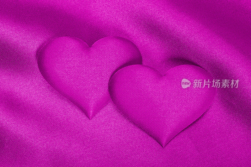 浪漫的背景(紫色绸缎上的一对紫心)