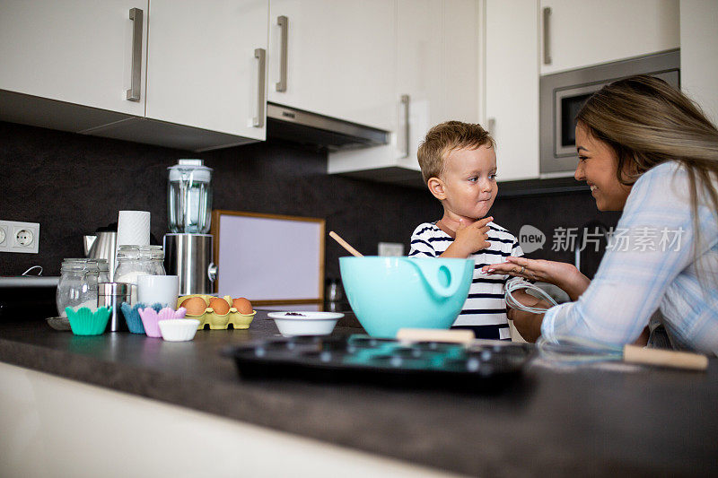 年轻漂亮的母亲和她的小儿子一起烤饼干