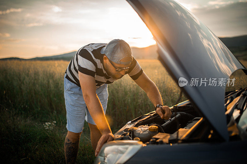 夕阳下，一个人在乡村公路上修车