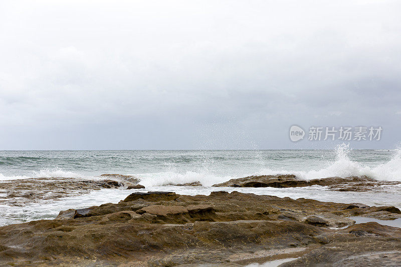 海浪撞击在海滩上的岩石，背景与复制空间