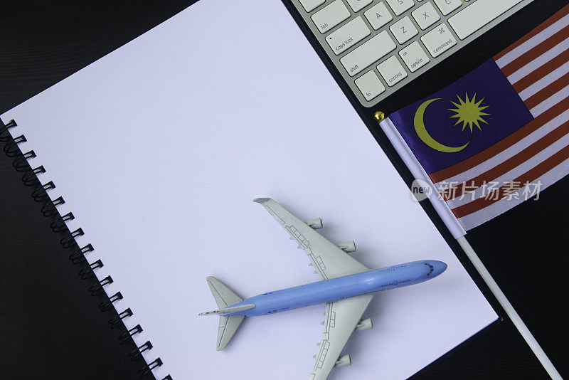 特写模型飞机，笔记本，马来西亚国旗和电脑键盘