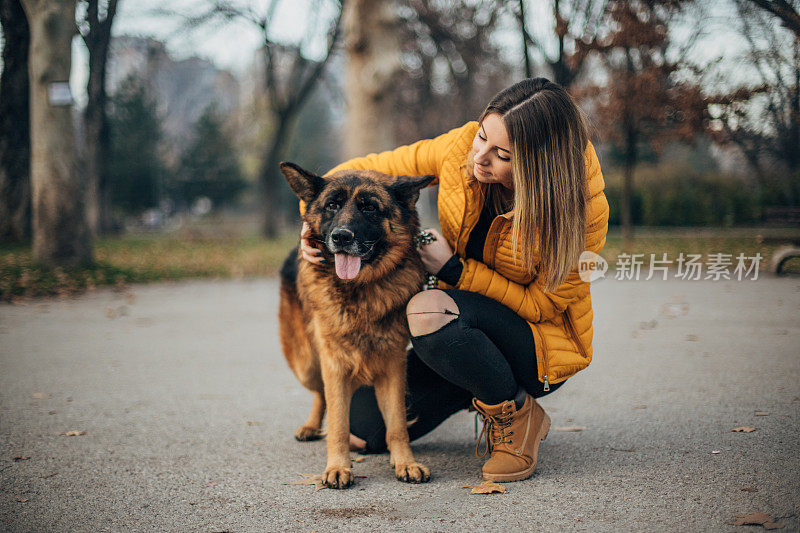 年轻女子和德国牧羊犬在公园里玩