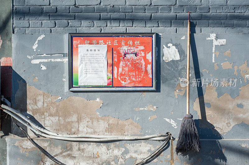 北京胡同里挂着拖把和布告栏