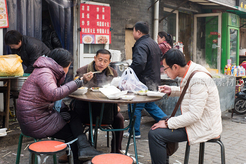 冬天的早晨，当地人在外面的小摊上吃中式早餐。
