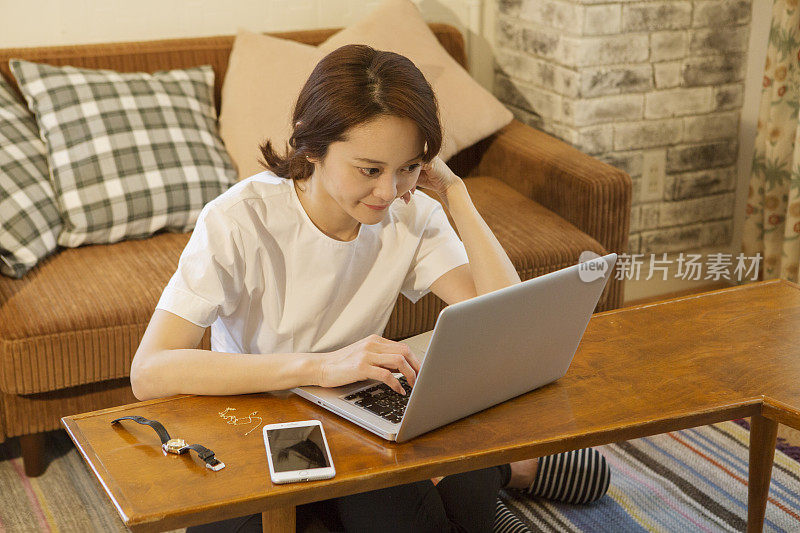 中年女性在客厅使用笔记本电脑