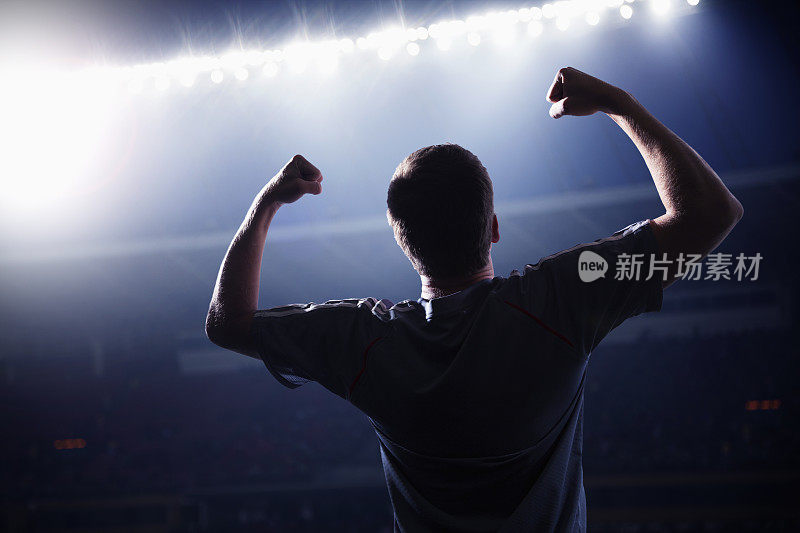 足球运动员在体育场里举起手臂欢呼