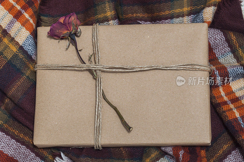 礼物包好，上面装饰着一朵花，放在毛毯上