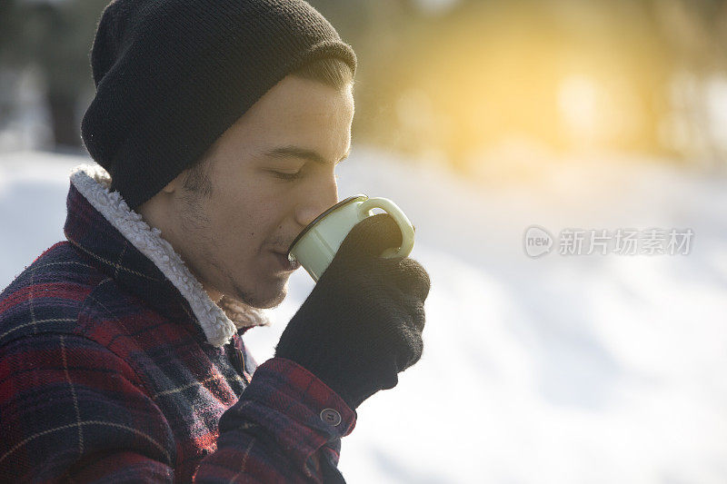 男人在山上拿着一杯热茶