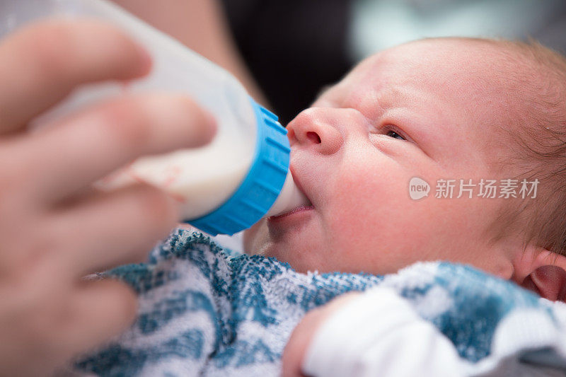 刚出生的婴儿在喝奶瓶里的牛奶
