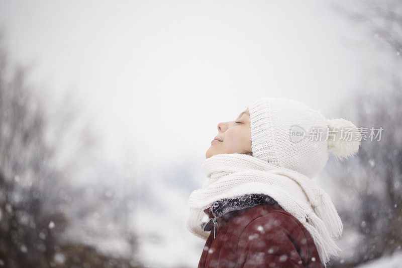 美丽的年轻女孩在户外玩雪的肖像