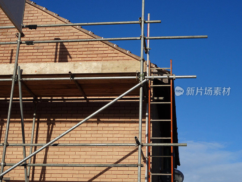 形象的现代红砖房子与脚手架杆子竖立，房屋维修