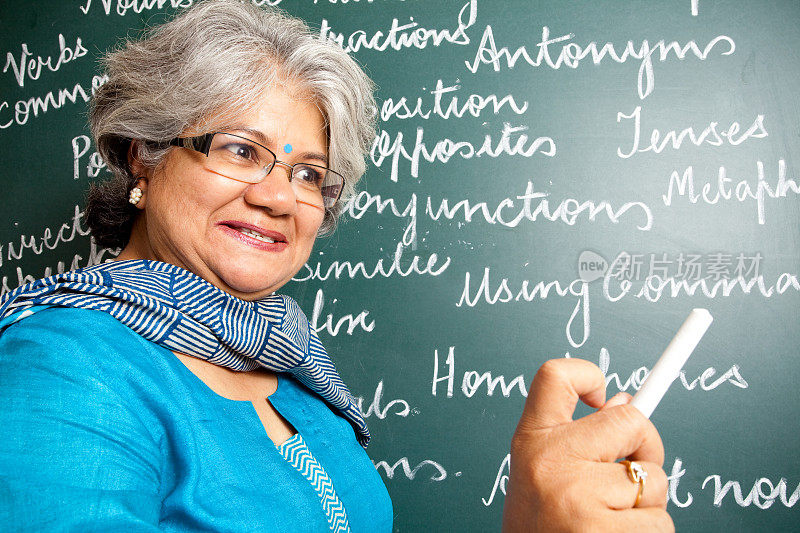 愤怒的印度亚裔女英语老师在教室与greenboard