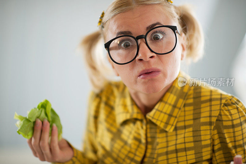 看起来很滑稽的怪胎手里拿着卷心菜叶。