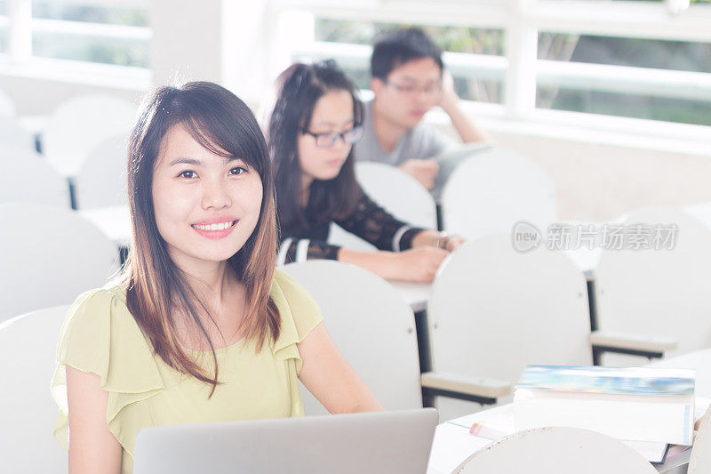 亚洲女孩在教室里用笔记本学习