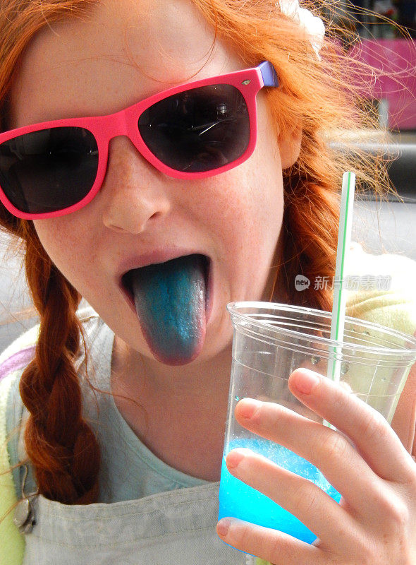 女孩喝冰沙饮料用吸管，冰冻的冰饮料，蓝色的舌头