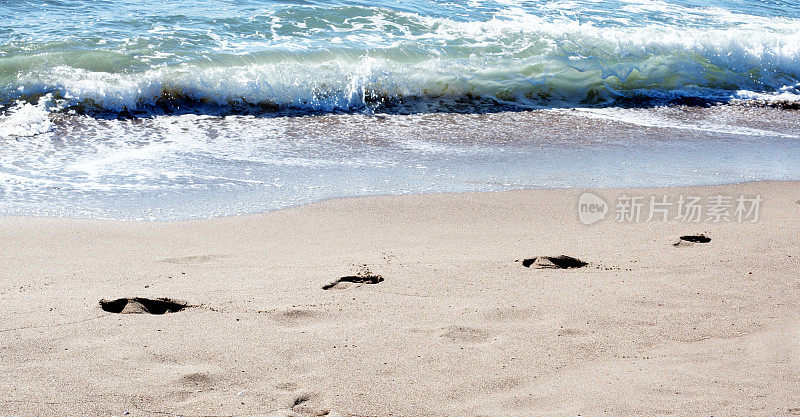 沙滩上的脚印和波浪