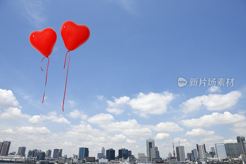 一对红心形状的气球漂浮在天空中