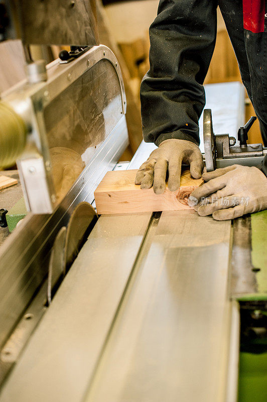 木匠使用桌子锯在木工车间，特写