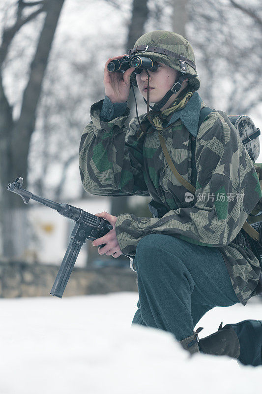 在射击场上用双筒望远镜观察目标的士兵