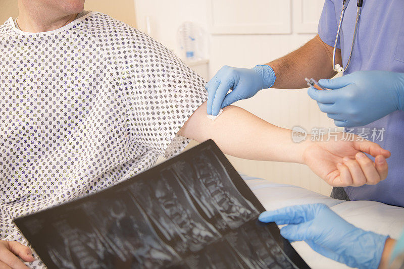 保健:男护士打针。医生检查病人的x光片。医院。
