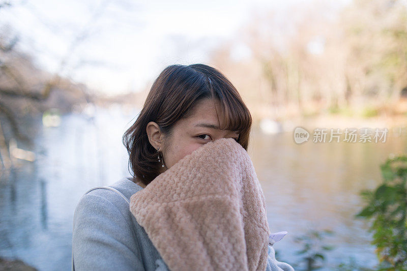 年轻女子用围巾暖脸