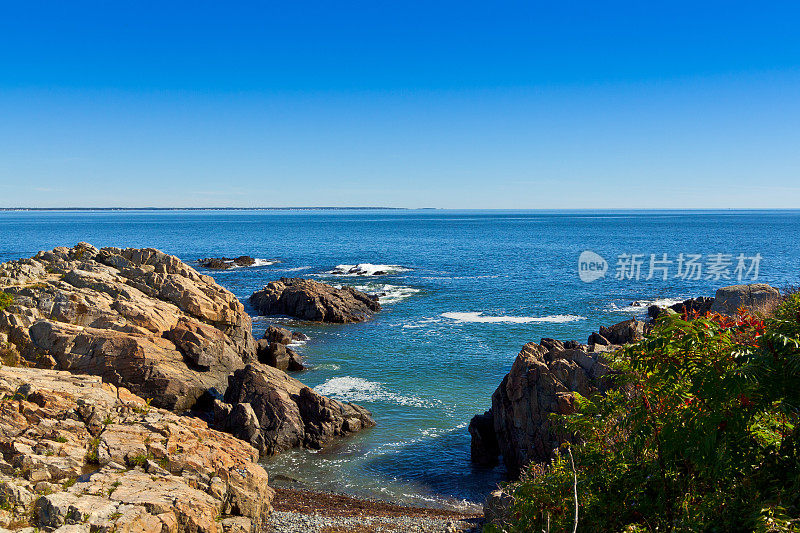 缅因州Ogunquit的岩石和海洋冲浪。蓝色的天空。