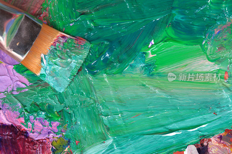 艺术家的调色板与绿色油漆和画笔