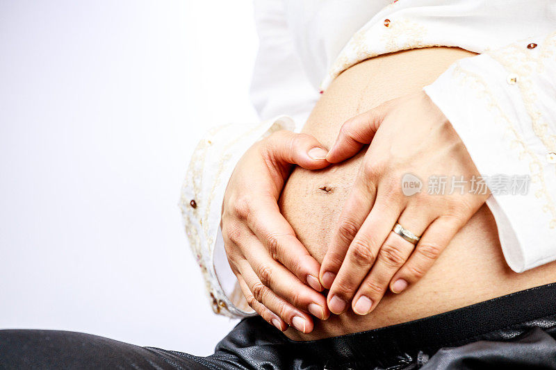 一名孕妇用手做出心形