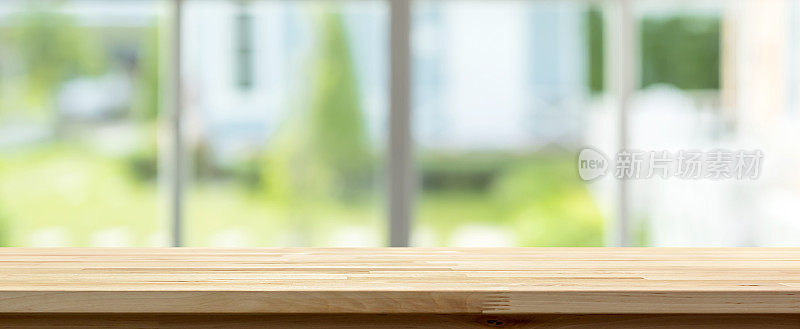 屋内的木质桌面与模糊的绿色花园，窗外的背景，全景横幅