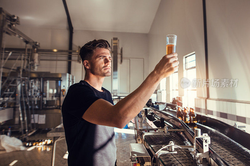 一个年轻人在啤酒厂检查精酿啤酒的质量