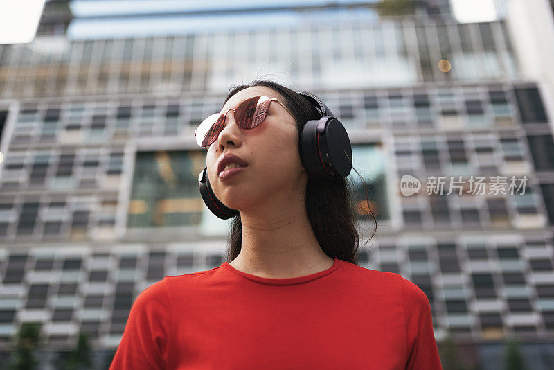 美丽的新加坡女人听音乐。