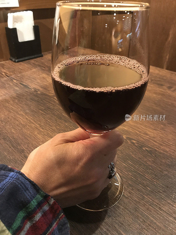 一位亚洲妇女端着一杯红酒