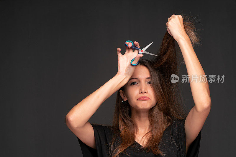一个年轻女子在剪自己的头发
