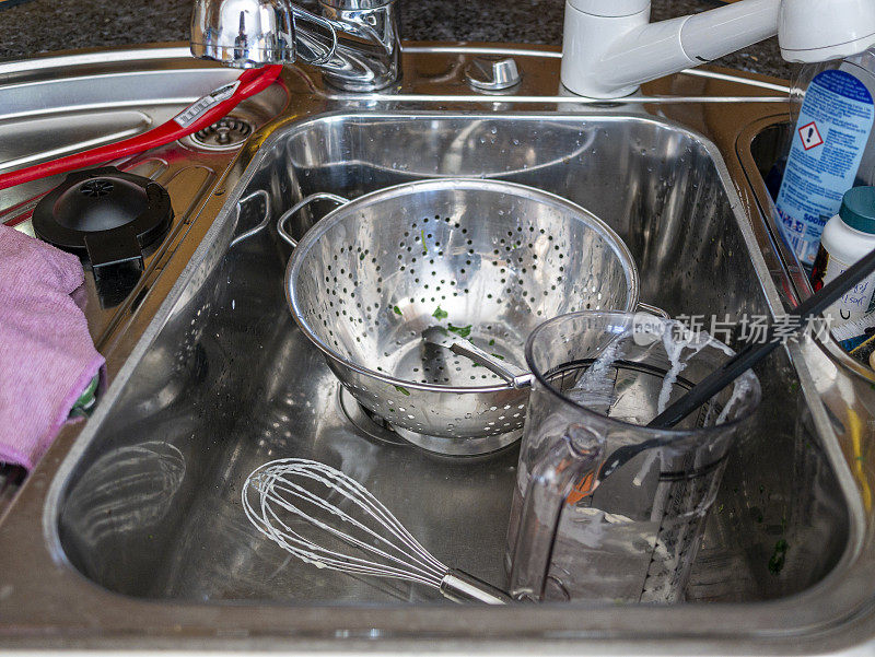 厨房水槽里的脏金属盘子