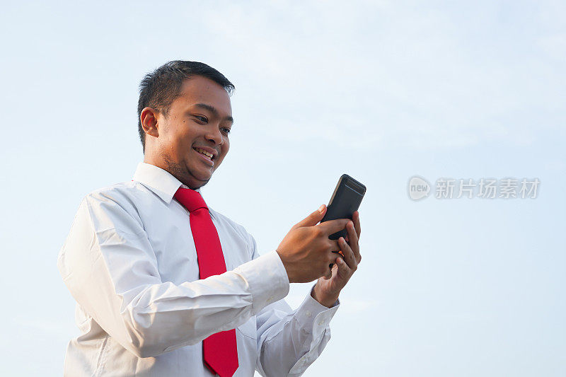 东南亚商人在手机上发短信