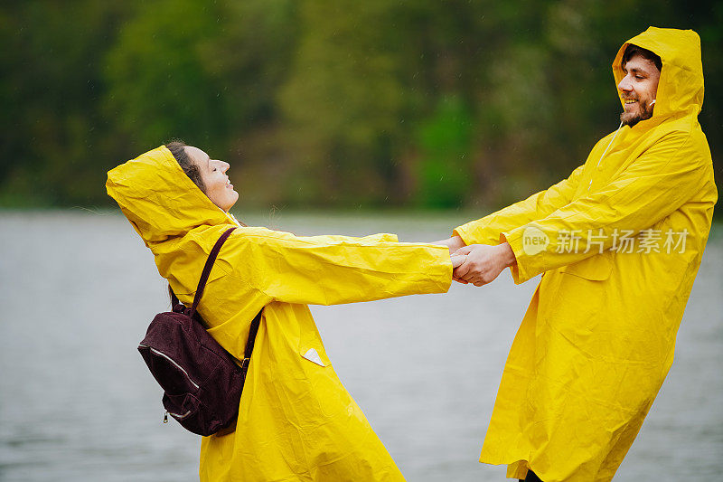 一对穿着雨衣的幸福夫妇站在码头上
