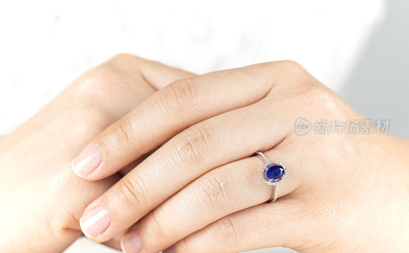 蓝宝石订婚戒指的女人手