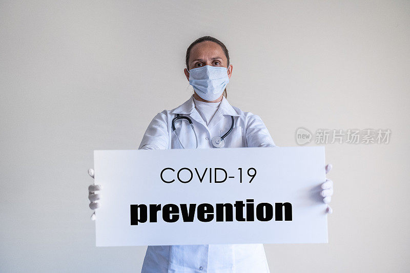 冠状病毒保护。手持冠状病毒防护标志的女医生。