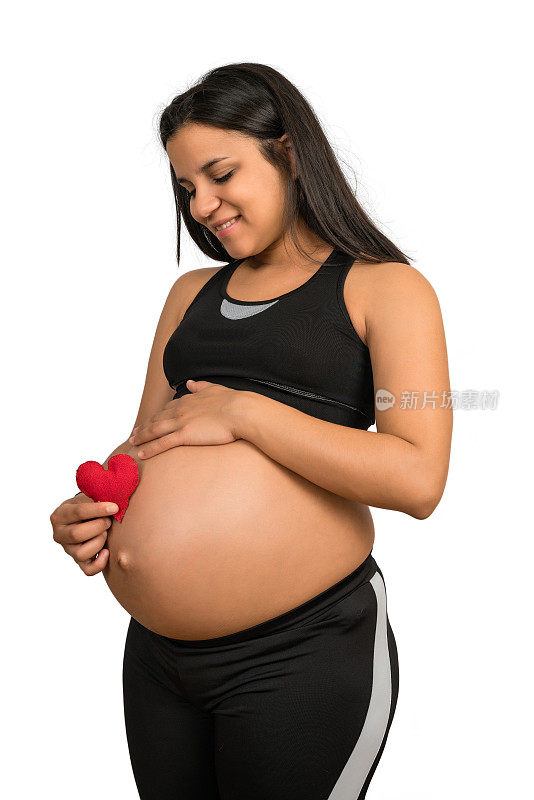 孕妇抱着心标志在肚子上。