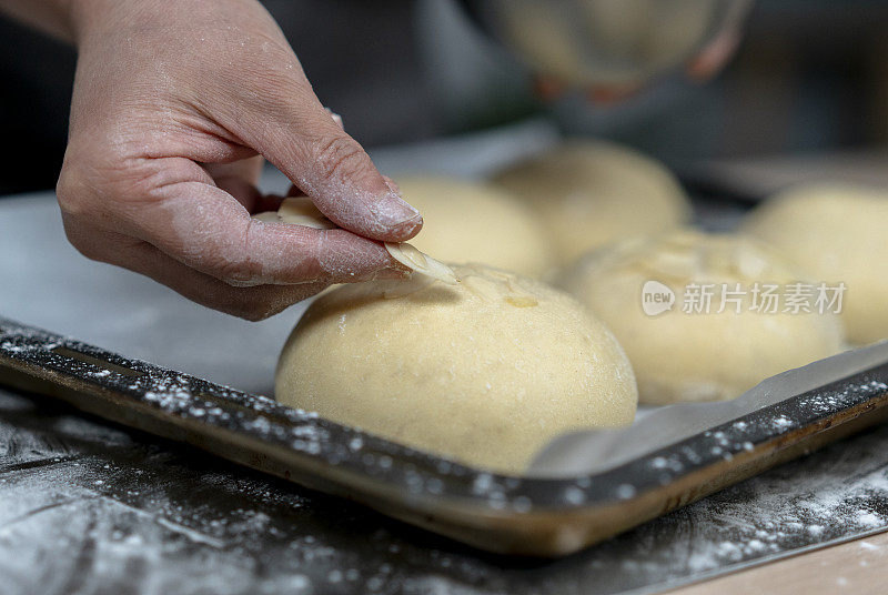 手工全麦面包:用杏仁片装饰面团，然后放入烤箱烘烤