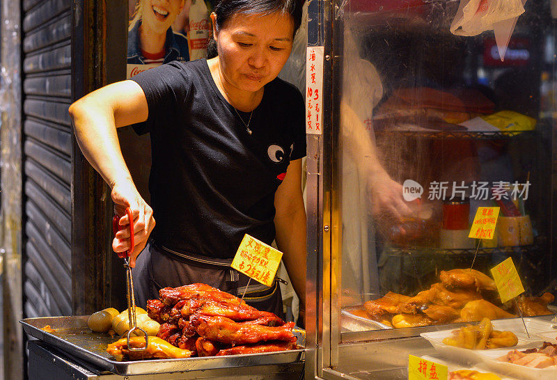 香港街头小吃摊贩，在晚上卖烤猪肉