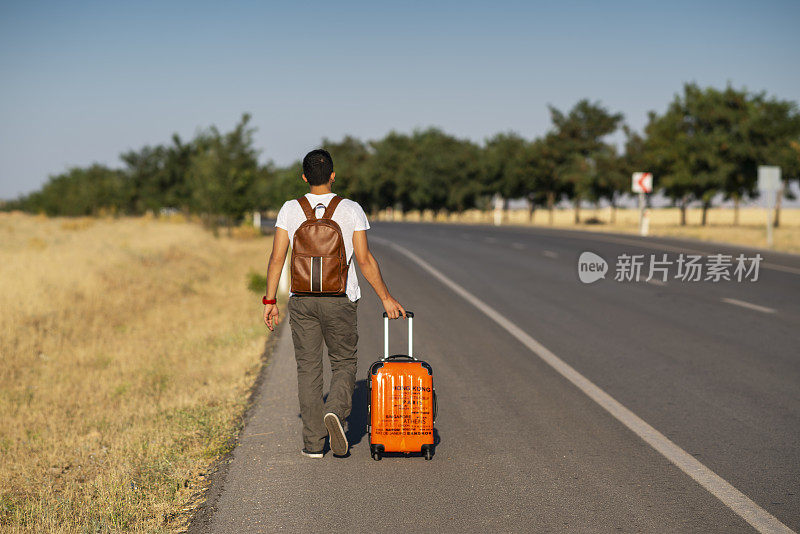 年轻的旅行者在路边搭便车