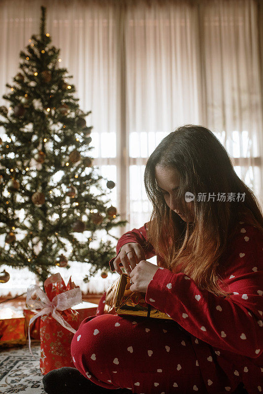 年轻女子打开圣诞礼物