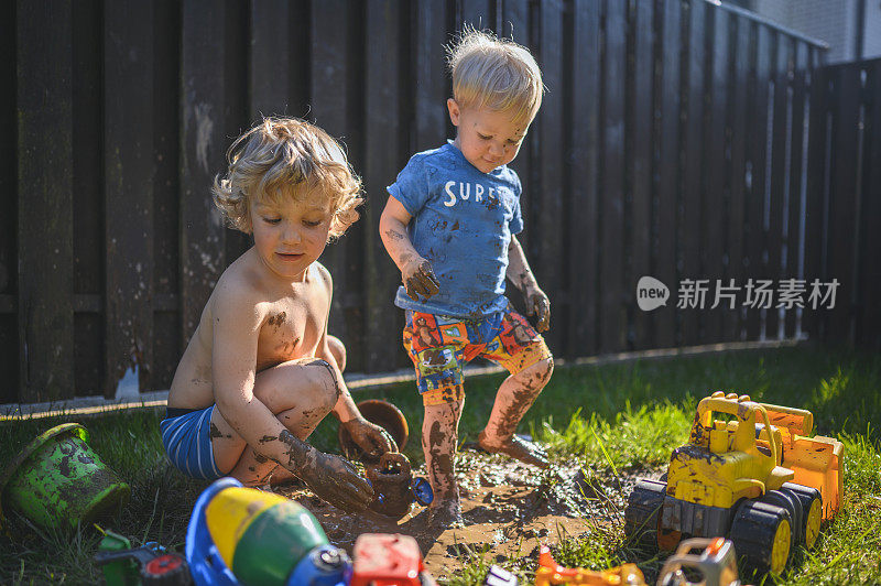 小男孩们在后院玩泥巴