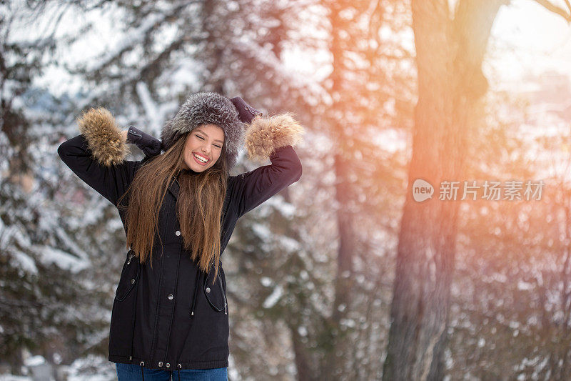 美丽的年轻女子享受在雪中