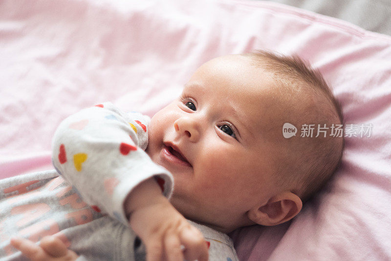 微笑的孩子。三个月大的小女孩玩着笑着。COVID-19大流行期间的新生儿。